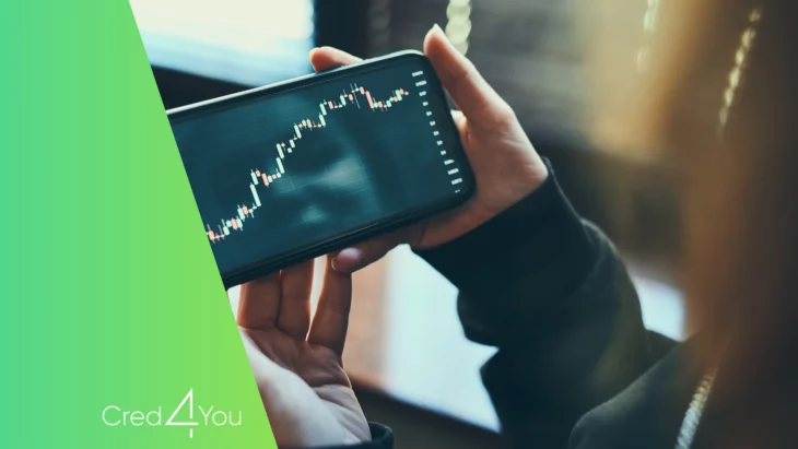 Pessoa segurando smartphone que exibe gráfico de variação financeira, representando o uso da tecnologia no setor FinTech.