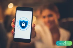 Mulher segurando um celular com ícone de cadeado e escudo na tela, simbolizando proteção digital e seguro de celular.