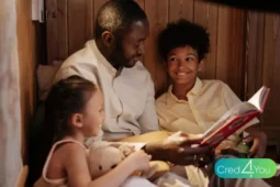 Pai lendo um livro para seus dois filhos sorridentes em um ambiente aconchegante, representando um momento especial de afeto no dia dos pais.