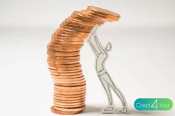 Pilha curvada de moedas sendo segurada por uma figura humana desenhada, simbolizando o impacto das finanças comportamentais nas decisões econômicas.