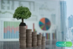 Pilha de moedas em crescimento com uma árvore no topo, representando o conceito de finanças verdes e investimentos sustentáveis.