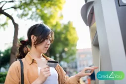 Mulher usando cartão pré-pago em caixa eletrônico ao ar livre