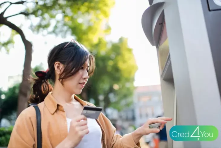 Mulher usando cartão pré-pago em caixa eletrônico ao ar livre