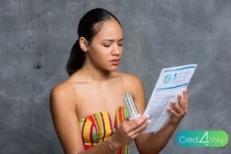 Mulher preocupada segurando uma lâmpada e uma fatura de energia — conta de luz mais cara