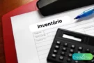 Documento de inventário com calculadora e caneta representando o cálculo do valor do inventário.