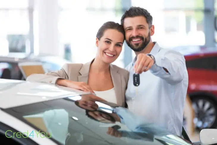 Lächelndes Paar mit Autoschlüssel nach erfolgreichem Autokredit