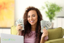 Frau mit Dollar-Scheinen und Laptop als Symbol für Gewinne durch Beliebteste Investitionen.