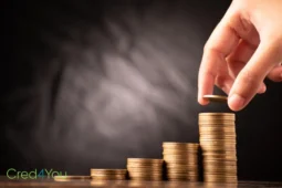 Hand stapelt Münzen als Symbol für ETFs und Vermögensaufbau