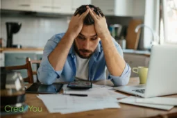 Gestresster Mann mit Rechnungen am Tisch, Symbol für Sparen Tipps 2025.