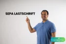 Mann zeigt auf den Schriftzug SEPA Lastschrift in einer informativen Grafik.