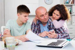 Haushaltsbuch führen im Alltag, Familie überprüft gemeinsam Ausgaben und Rechnungen