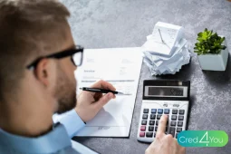 Homem analisando contas e recibos com calculadora sobre a mesa, identificando despesas invisíveis que impactam o orçamento doméstico.